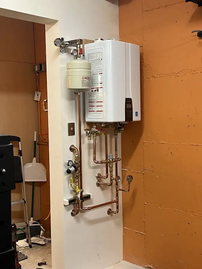 Plumbing technician inspecting water heater connections in Rio Rancho